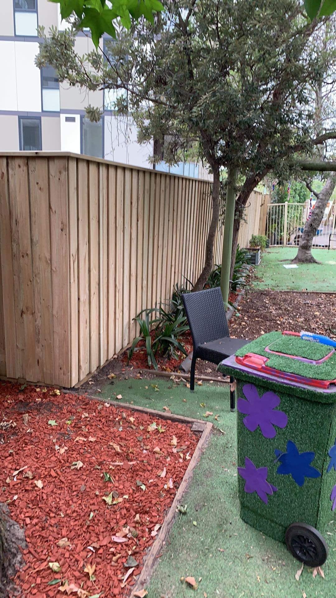 Treated pine timber fence enclosing a small courtyard with paved surface at a Sydney property
